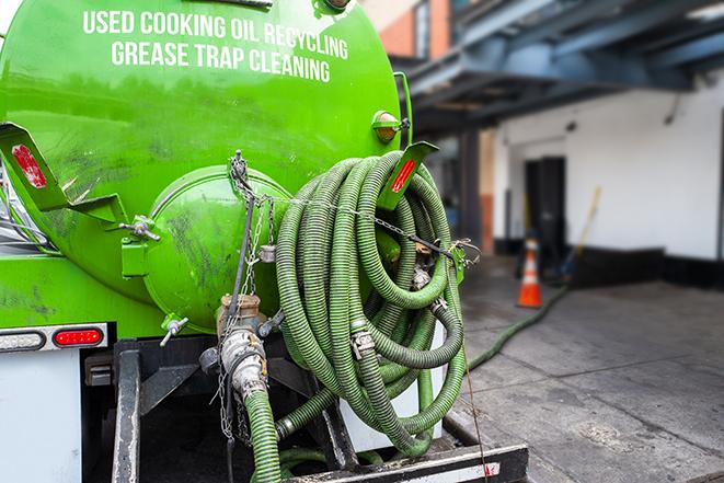 a grease trap being pumped by a sanitation technician in Buckner, MO